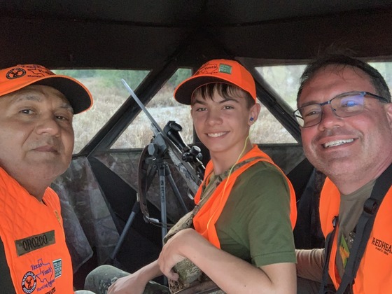 Student and mentors pose riding in a off road vehicl