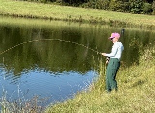 Picture of girl with fish on the line.