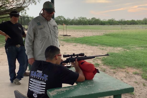Teenager shooting from a shooting table at a range