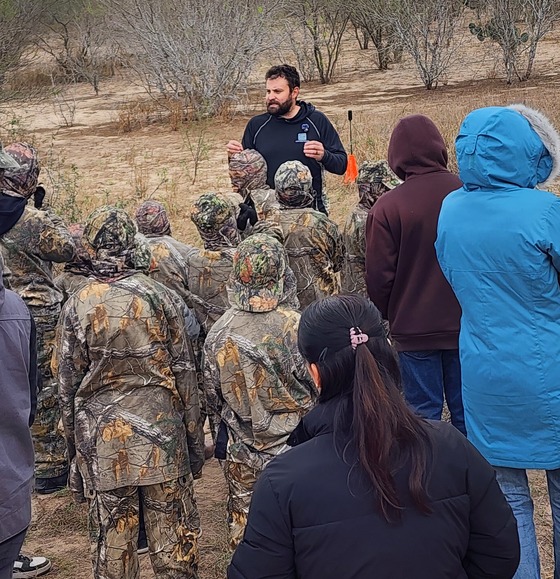 Archery instructor teaches kids in camouflage