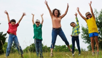 Woamn and children jumping in the air