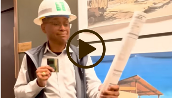 Man in hardhat holds a map, video link