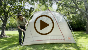 Woman putting up a white tent, video link