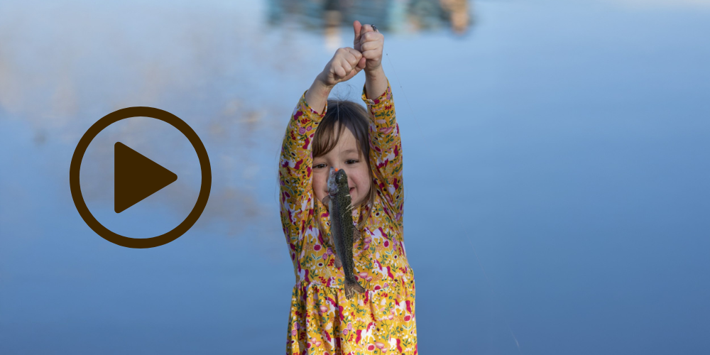 young girl holding up trout on line, video link