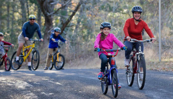 Family biking on paved trail, link