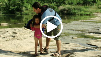 Dad adjust life jacket on child, video link