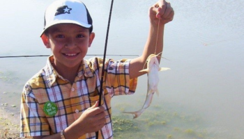 Boy with catfish on a line