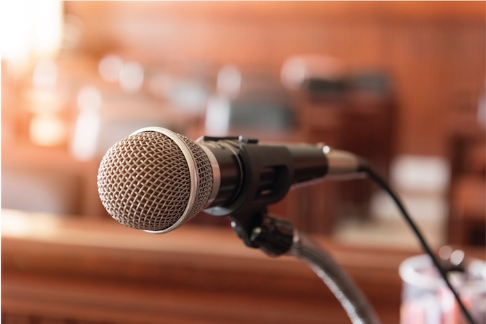 A microphone with table and chairs blurred in the background
