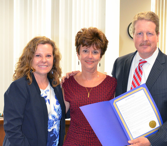 Board chair Donna Bahorich, left, and SBOE member Tom Maynard, right, present a resolution to Sharon Pierce.