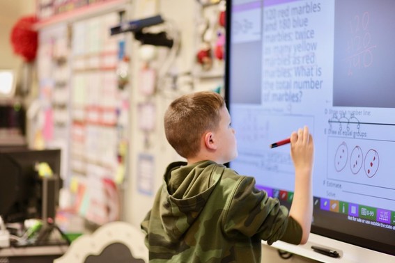 boy in class working on smart board