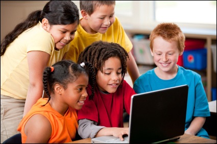 students gathered around computer on desk