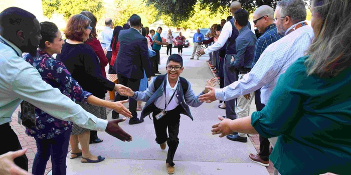 student getting high-fives on first day of school receiving line