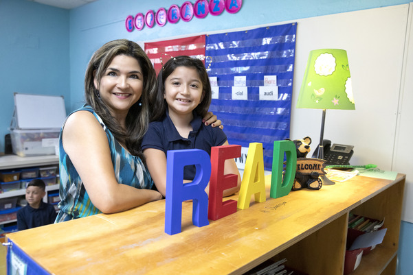 image of adult and child near a sign that says "READ" 