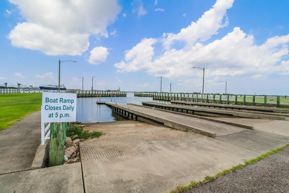 The pier at Sabine Pass SHS and sign saying "Boat Ramp Closes Daily at 5 p.m."