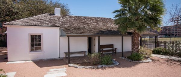 Casa Navarro, a single-story adobe house with a palm tree in front