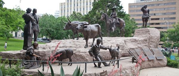 Large monument with figures of a family, a mounted vaquero, a conquistador, and two longhorns
