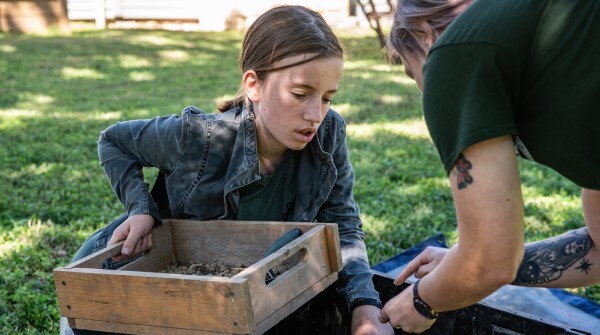 Girl participates in a guided archeology activity at the 2023 Archeology Fair at the French Legation