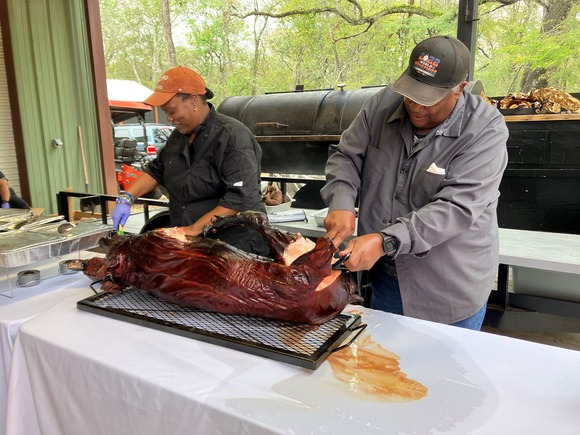 a woman and man slicing cooked meat