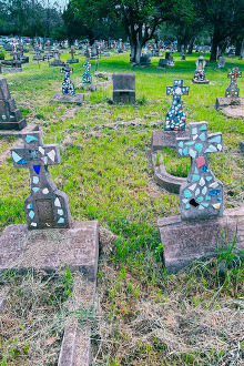 Traditional Mexican concrete cross headstones embedded with colorful tiles, located in Panteon Hidalgo in New Braunfels, Texas