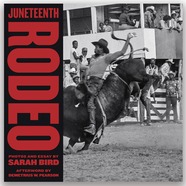 Black cowboy riding a bull at a rodeo. 