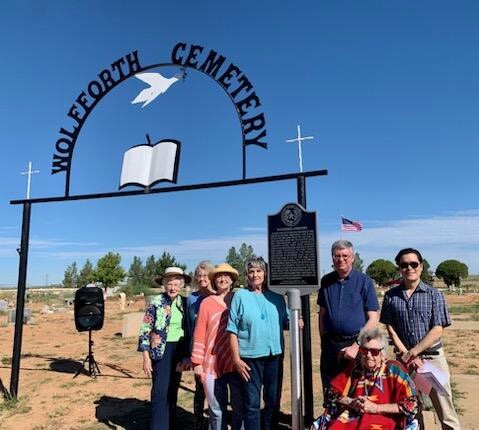 Members of Lubbock CHC and Wolfford Cemetery Association gather around a historical marker at the cemetery's entrance