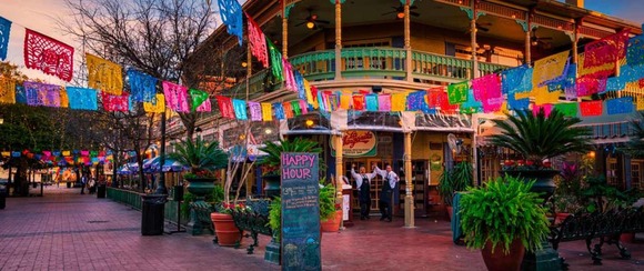 People in front of a restaurant with colorful streamers hanging from the building