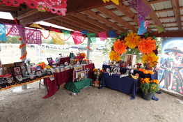 Photo of a colorful traditional Mexican altar with photographs of families buried at San Pedro Cemetery in San Marcos, Texas