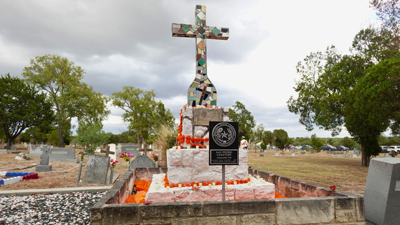 Colorful Mexican tile cross with marigold flower decorations for Day of the Dead in the San Pedro Cemetery