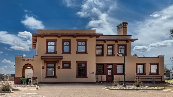 Two-story cream building with dark red trimming