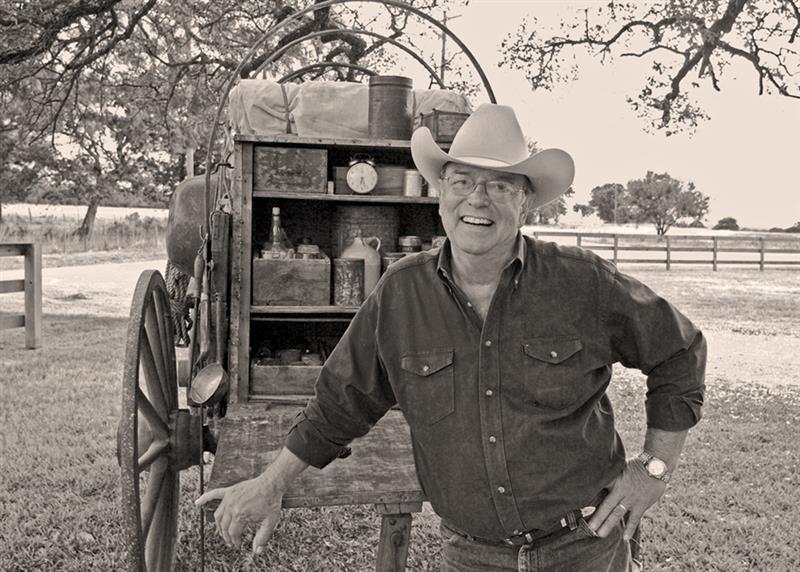 Tom Perini stands in front of a chuckwagon 