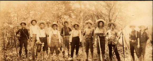 Several men stand with shovels black and white photo 