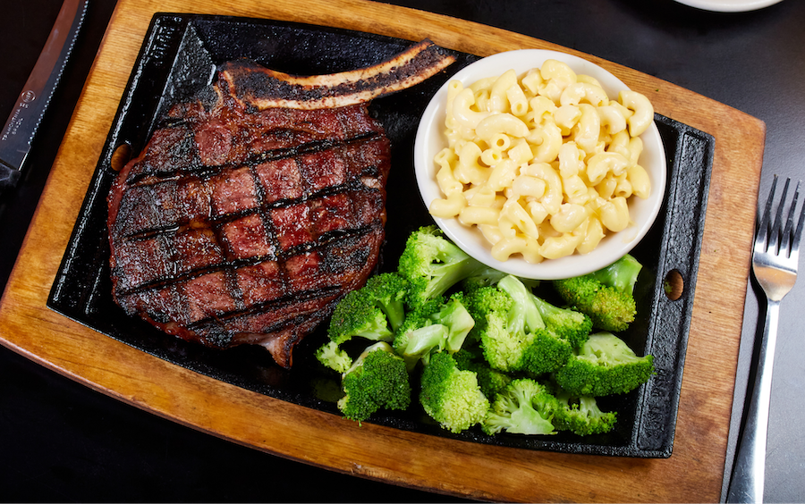 Steak on a black plate with broccoli and potatoes 