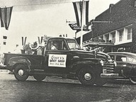 a 1950s pick up truck with a boot shop sign onhte side