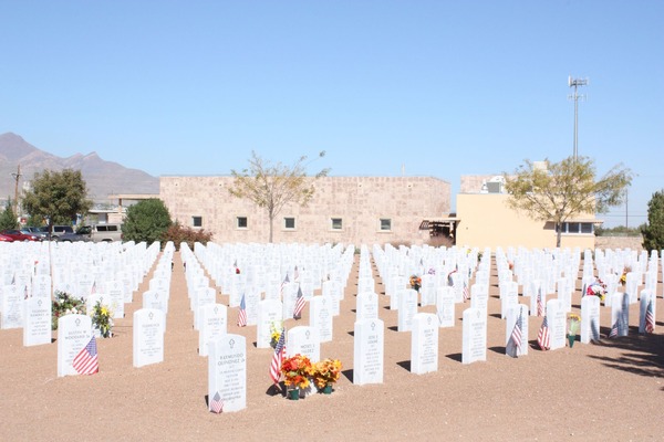 Rows of white military headstones at Fort Bliss National Cemetery in El Paso