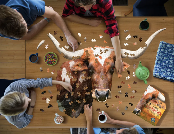 Group of people around coffee table putting together a longhorn puzzle