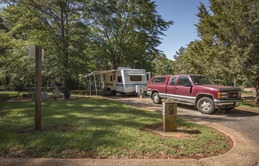 Truck towing a camper parked in camping spot