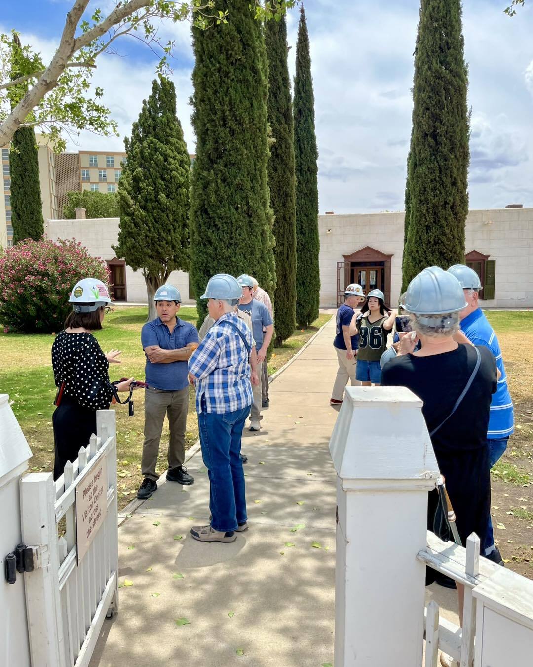This photo shows guests touring a 19th century home while wearing hard hats.