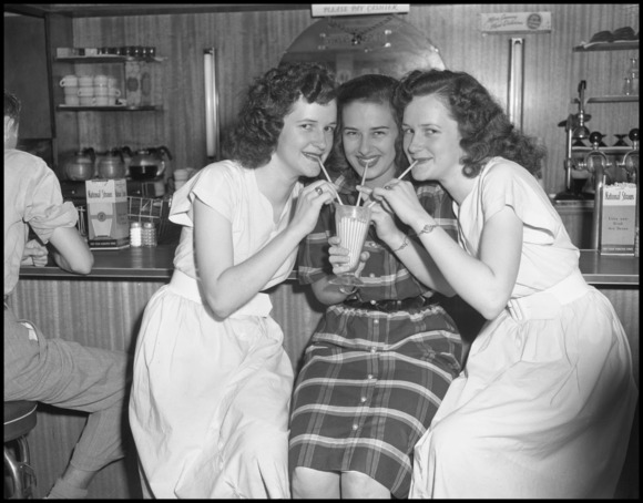 Three women at soda fountain b/w 