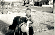 Black and white photo of child holding dog