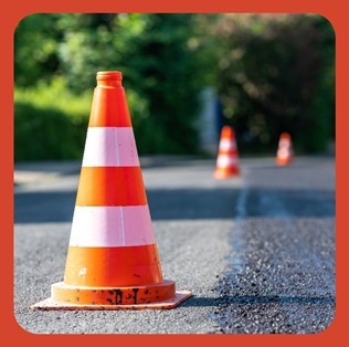 Image of a road closure with orange cones.