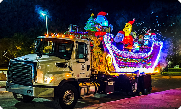 Solid Waste Grinchmobile decorated with holiday lights, bubbles, and the Grinch.