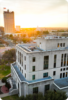 Aerial view of Downtown Waco over City Hall with the ALICO building and a sunset in the background