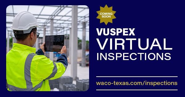 Worker in safety uniform taking a picture of a construction site with an iPad