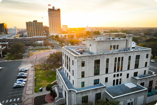 Aerial view of City Hall with downtown in the horizon and the sun setting.