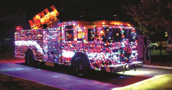 Red fire engine decorated in Christmas lights