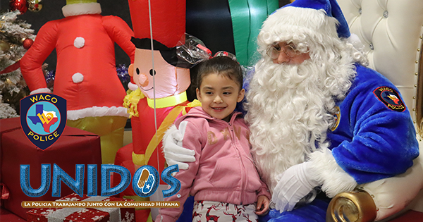 A little girl on Blue Santa Claus's lap