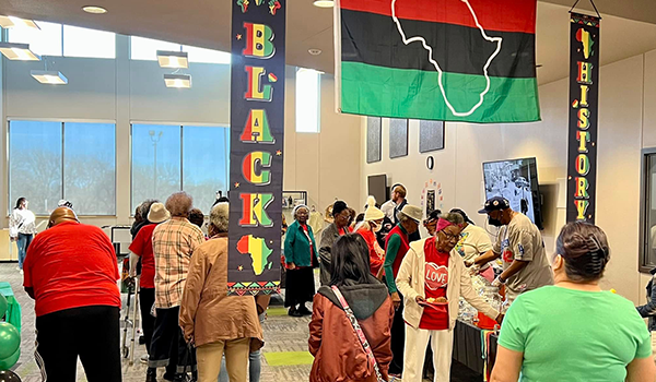 People gathered around mini exhibits containing Black History