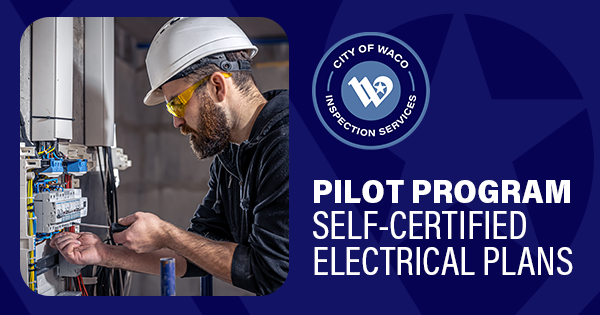 An electrician working on an electrical panel