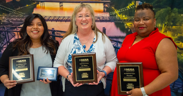 Three women holding awards
