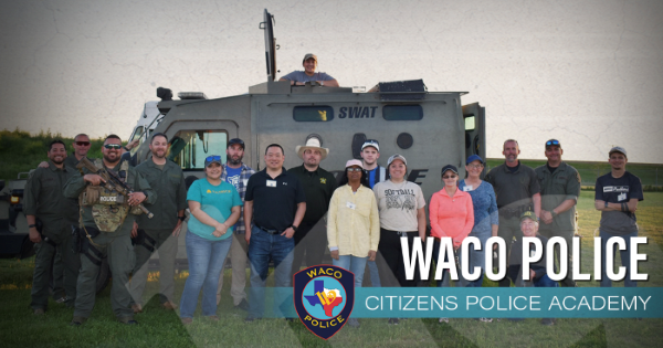 Group of people standing in front of a SWAT van